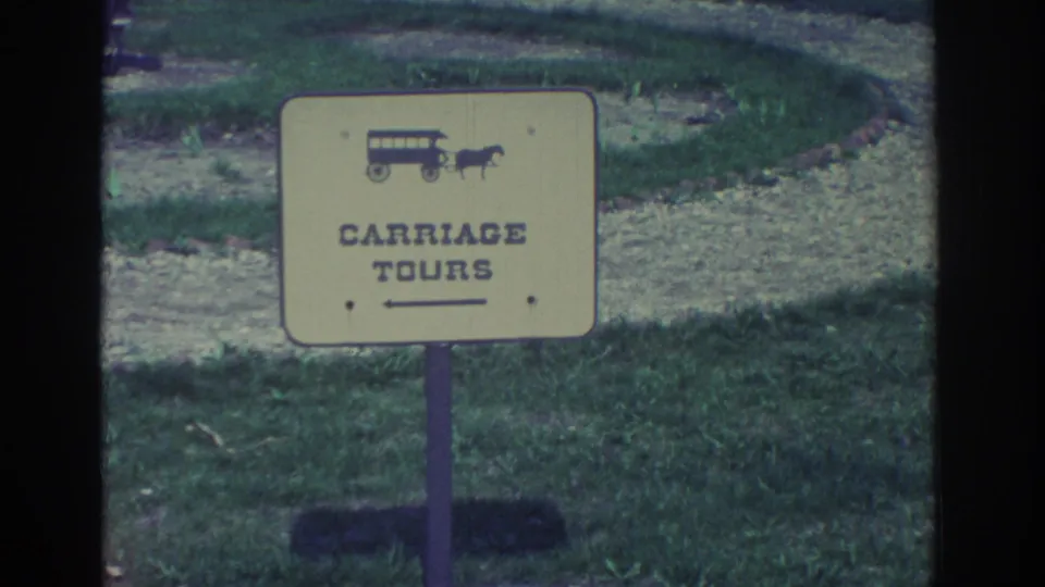 The final frame holds on the yellow Carriage Tours sign in a grassy area, showing soft focus, visible grain, and contact-sheet frame edges.