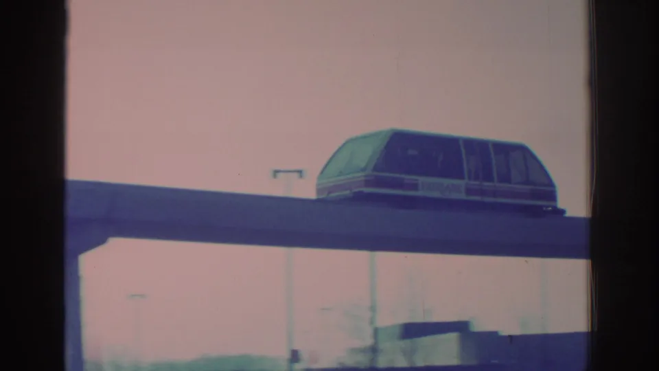 1972 Toronto home-movie frame with a close pass of the enclosed elevated transit car on a raised track.