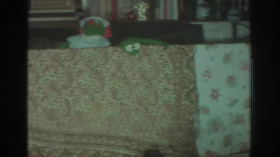 A frog puppet remains partly visible behind the tablecloth in the 1972 Toronto home-movie interior.