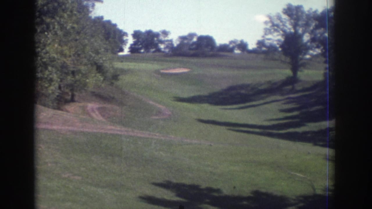 1972 Toronto 8mm frame showing a green golf-course fairway with sand trap, mature trees, and bright daylight.