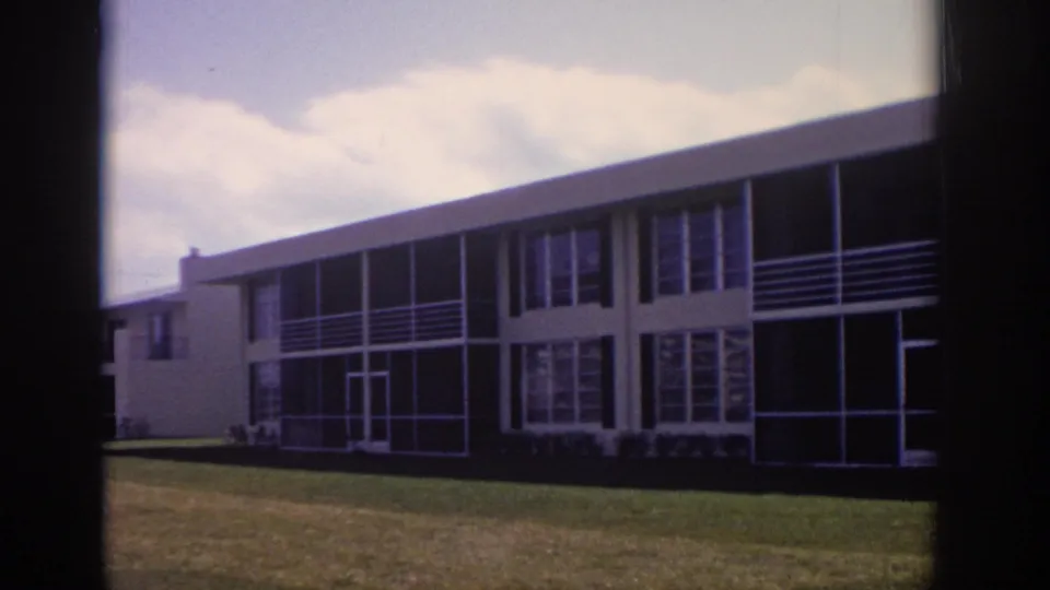 1973 Naples, Florida frame showing the building from the lawn, with an adjacent structure visible at left.