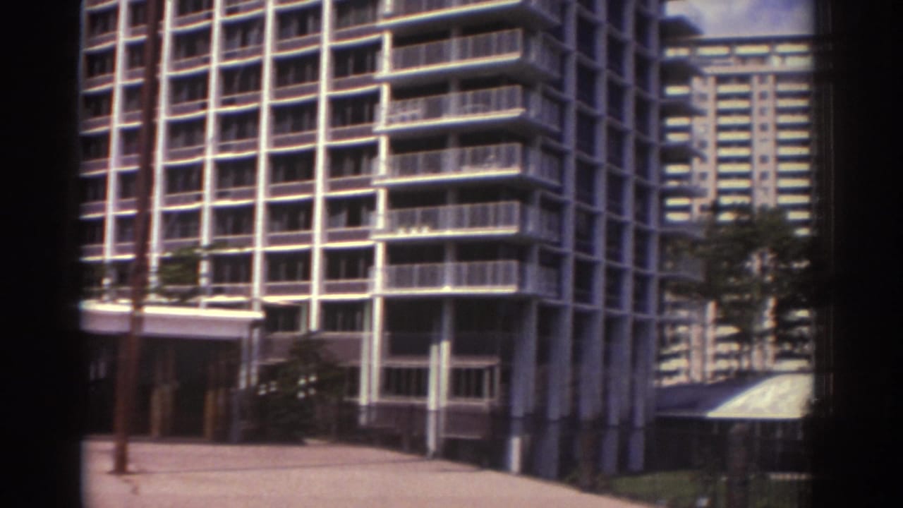 High-rise apartment buildings with balconies seen from a sidewalk area.