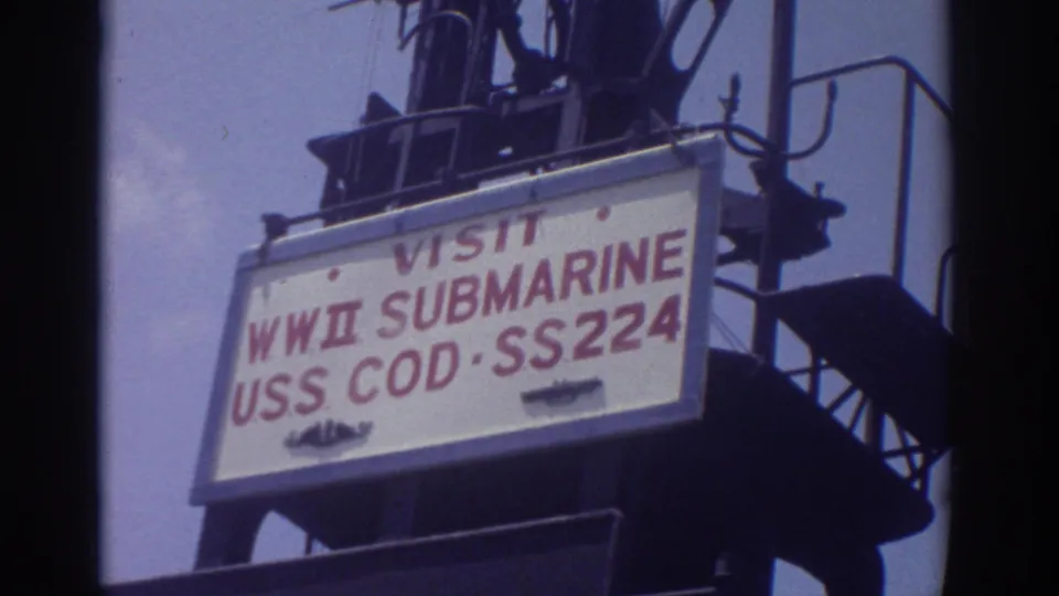Sign on a metal stair structure reads VISIT WWII SUBMARINE USS COD SS224, identifying the historic submarine exhibit.