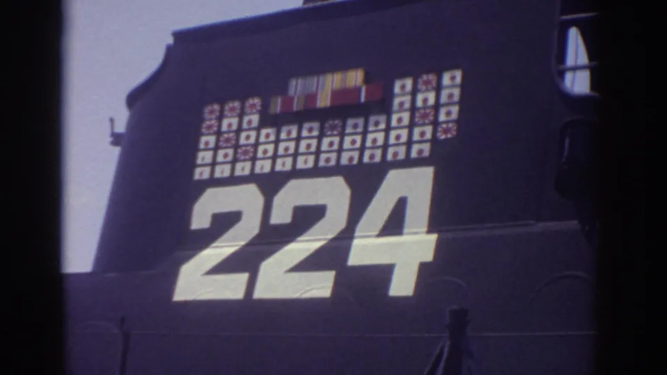 1974 Cleveland 8mm frame showing a close view of a preserved military submarine hull marked 224 with rows of painted insignia above.