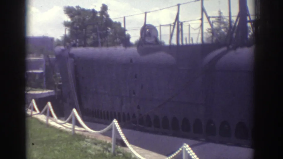 1974 Cleveland 8mm frame widening to show the preserved submarine display behind fencing and a rope barrier on a grassy outdoor site.