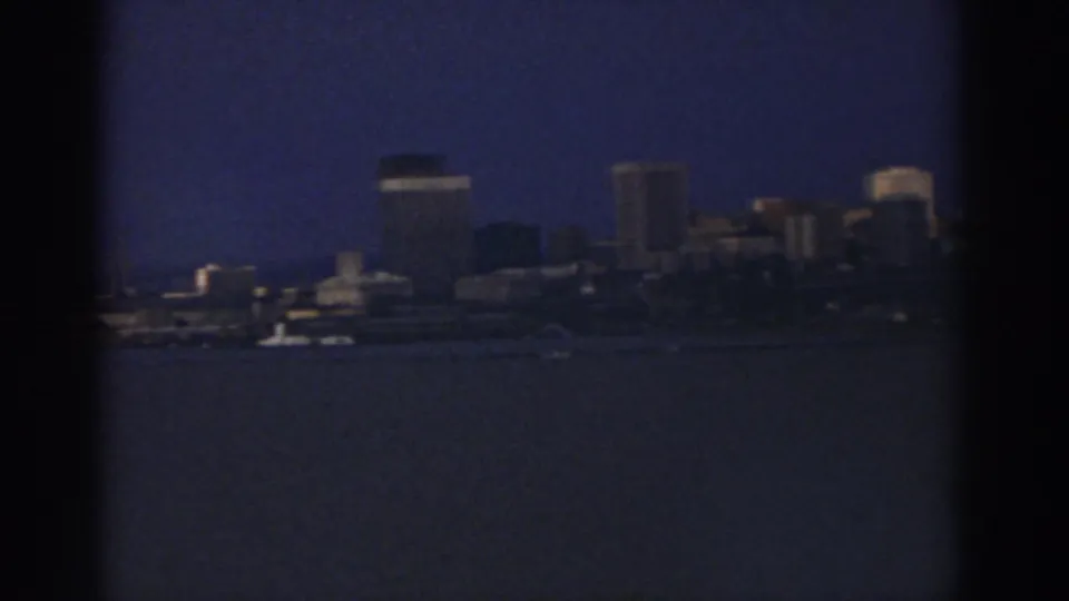 A section of the Cleveland waterfront skyline appears through soft 8mm focus, with water in the foreground.