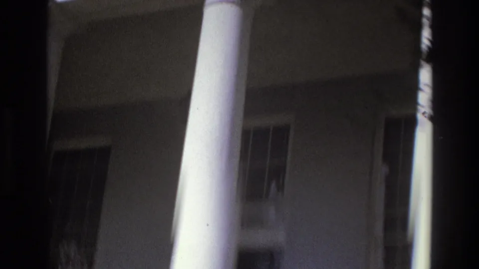 1975 Atlanta 8mm frame showing a white-columned building exterior with windows and deep shadow.