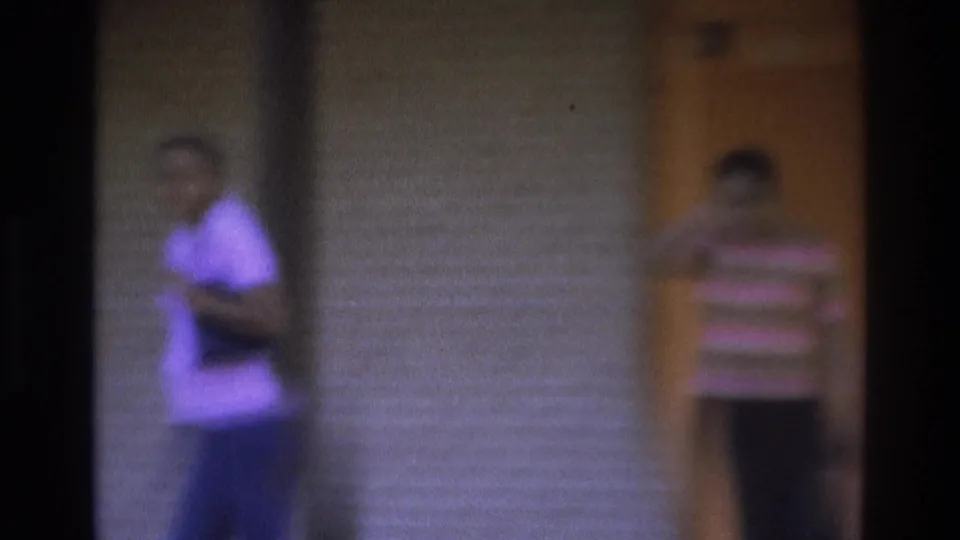 1975 Atlanta frame showing two women on a brick residential porch area, one by the orange door and one farther left.
