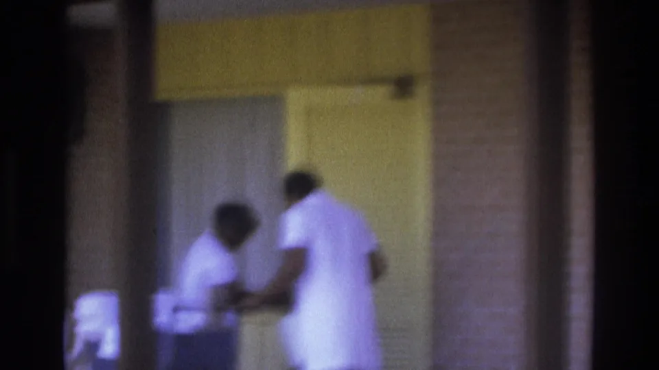 Atlanta 1975 frame showing two women in white uniforms working together near an exterior doorway.