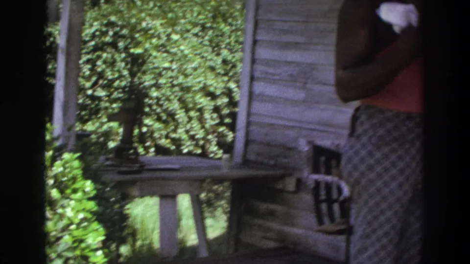 The final porch view shows green foliage beyond the railing, a small table or stand, white siding, a chair, and a partially visible adult at frame edge.