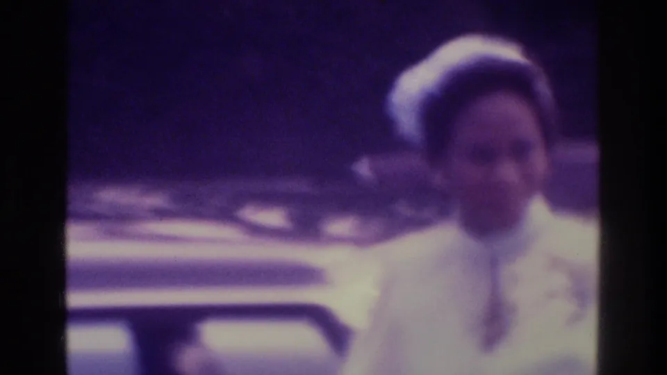 A soft 8mm close-up shows the bride in white near the car, with strong purple color shift and shallow detail.