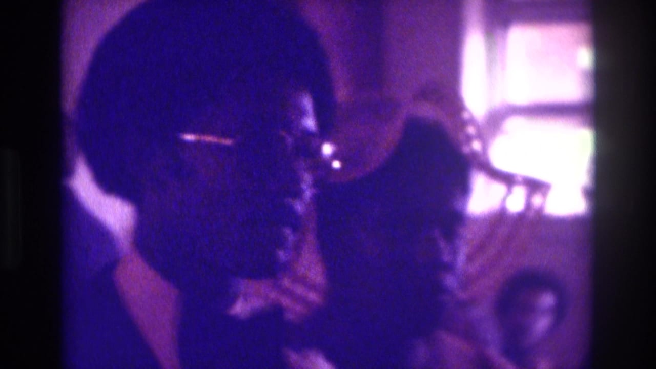 Man and woman face each other during a dimly lit wedding ceremony moment.