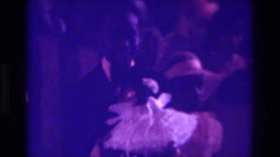 1975 Atlanta wedding footage appears to show a light-dressed flower girl or attendant near a dark-suited member of the procession.
