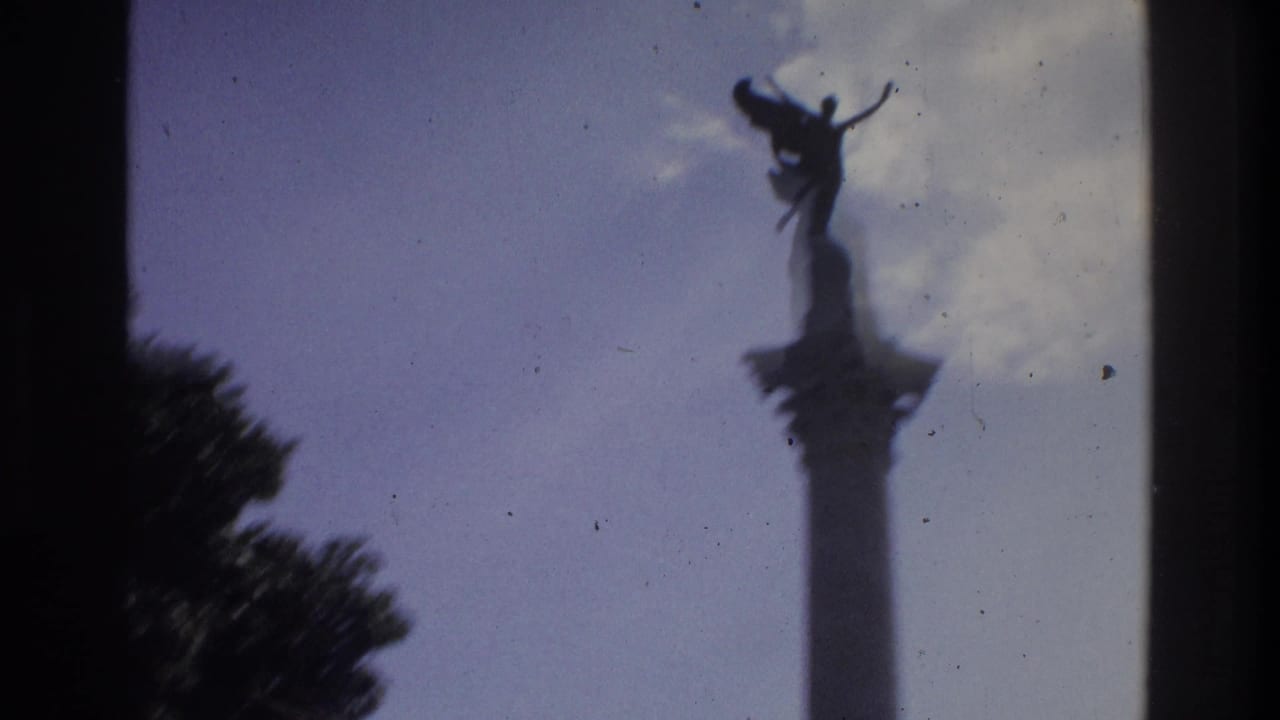 1975 Atlanta 8mm frame with a winged statue and column seen at a distance through dark window-like edges.