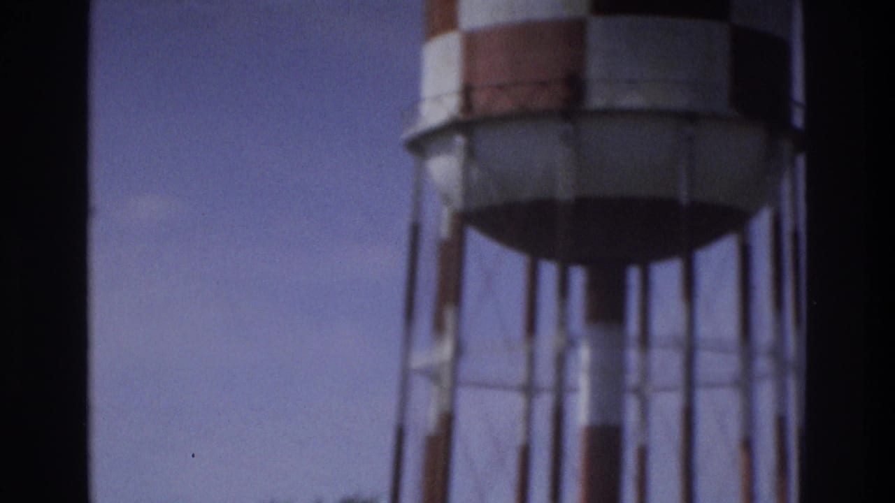 1975 Atlanta 8mm frame showing a water tower partly cropped by dark frame edges and soft focus.