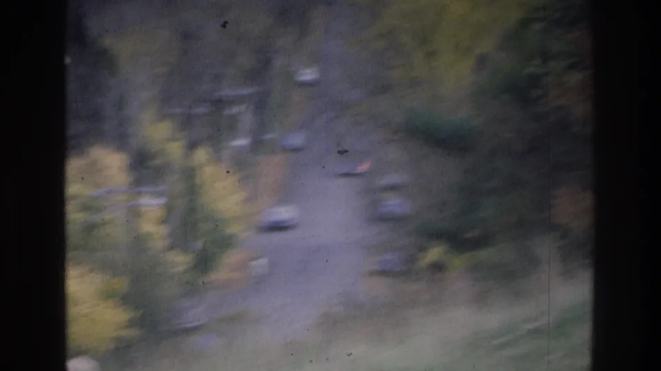 1975 Atlanta-area traffic appears on a curving rural road, with muted autumn trees and visible film wear.