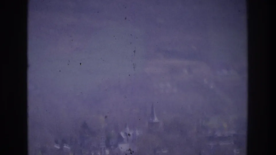 Hazy 1975 Atlanta-area road view with distant cars, roadside trees, and pronounced home-movie film texture.
