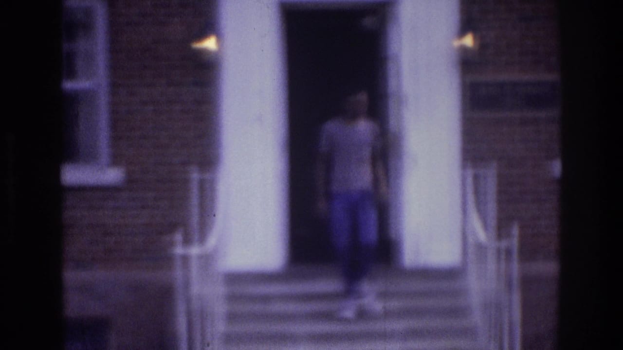 Teenager begins descending steps outside a brick building with columns and railings.