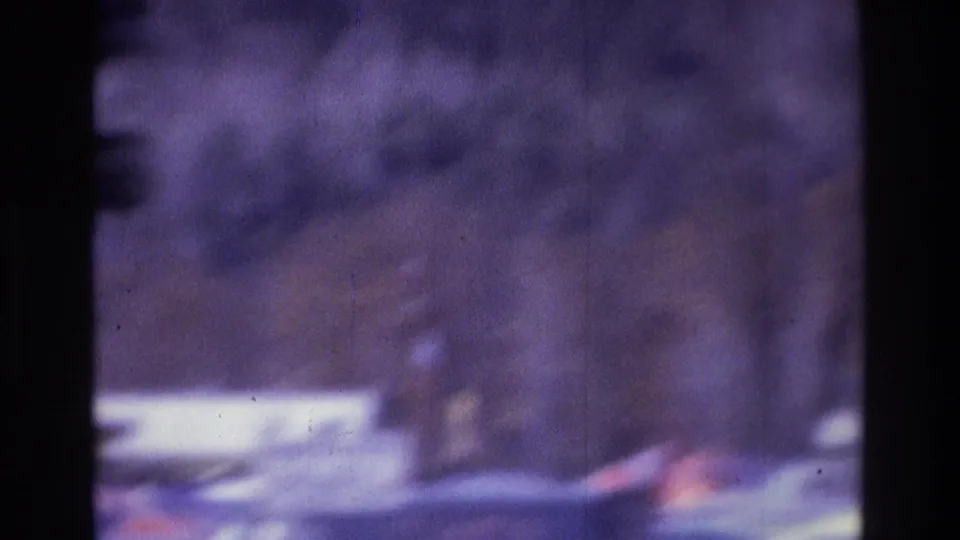 Soft 8mm frame from Atlanta showing parked cars, trees, and a residential roadside area with no clear readable signage.