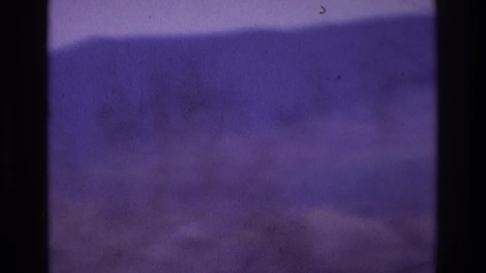 Soft purple 8mm frame from the supplied Atlanta 1975 clip, showing an indistinct water or sky surface with a dark foreground band.
