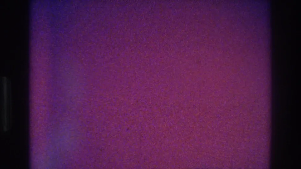 End frame from the 1975 Bronx 8mm clip, largely obscured by purple-pink grain with little visible subject detail.