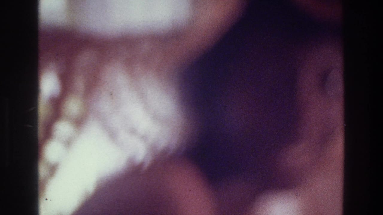 1975 Bronx 8mm frame with a heavily blurred close-up figure, purple color cast, low light, and visible film grain.