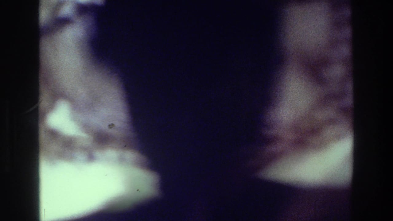 Soft, dark frame with blurred guests and a pale tabletop or light area at the lower left.
