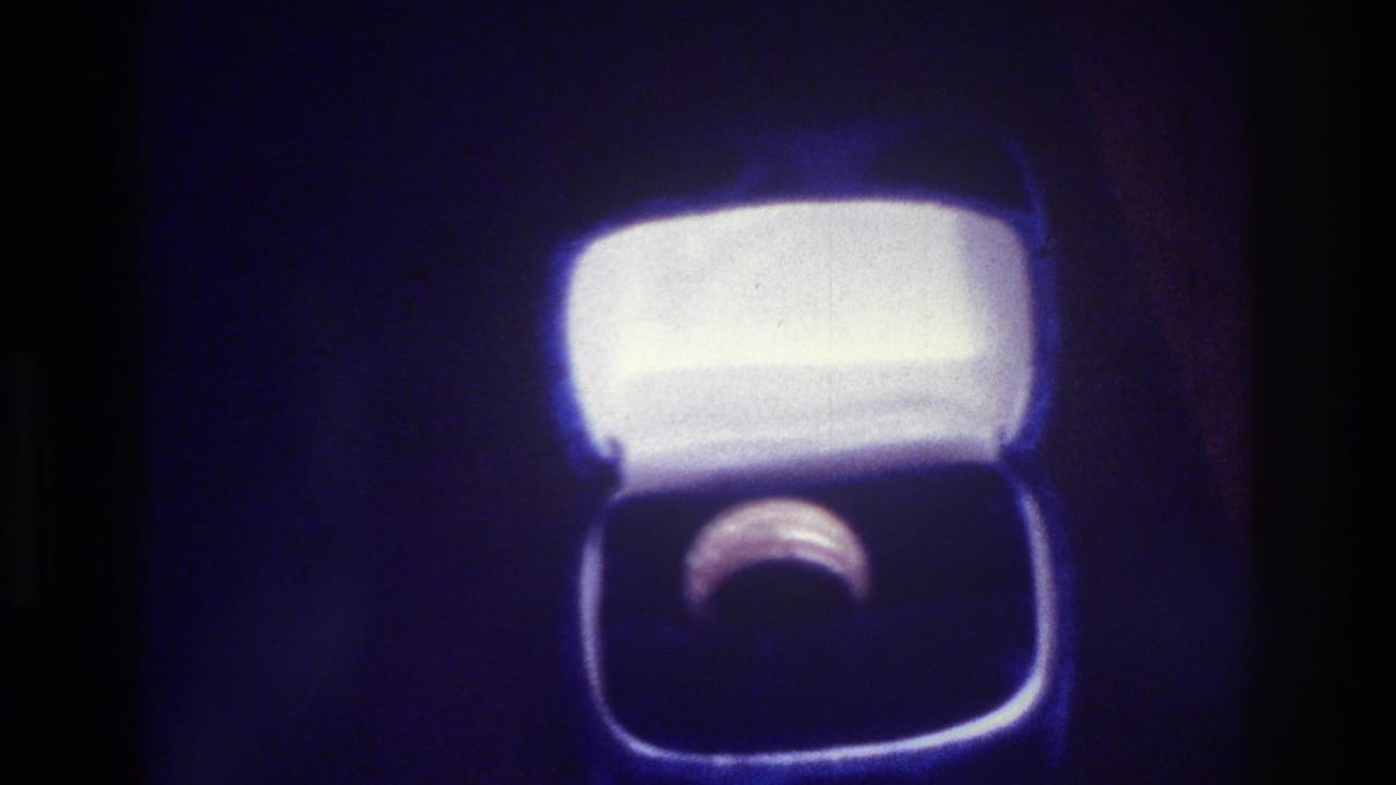 1975 Bronx 8mm frame showing a ring in an open white-lined box under dramatic blue-tinted lighting.