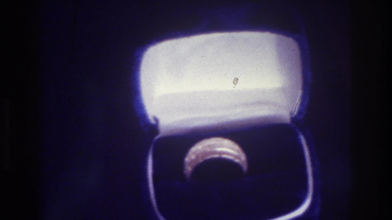 Close-up of a ring in an open box with bright white lining.