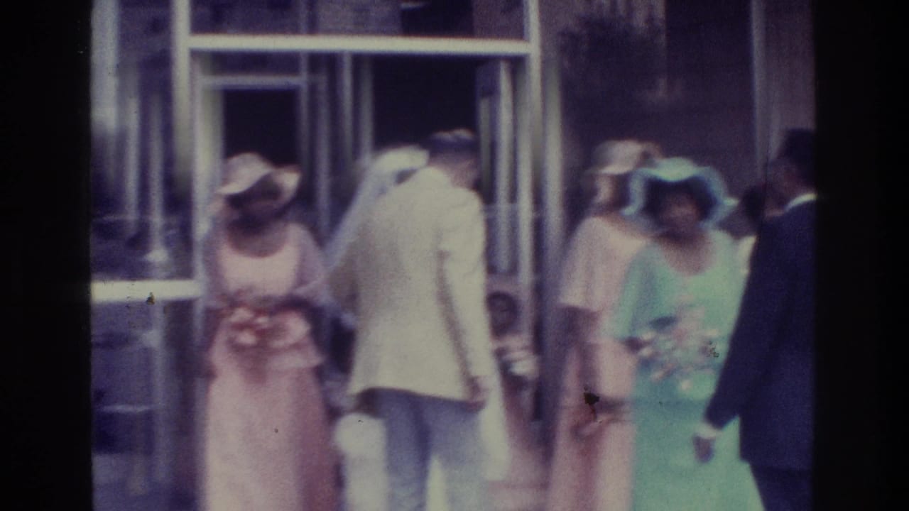 Bronx wedding exit scene with attendants in pink and mint dresses, a bride in white and suited guests near the chapel entrance.
