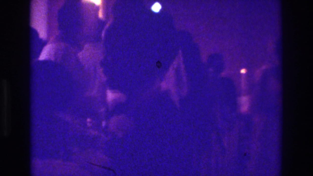 Dark church scene with worshippers gathered near candlelight.
