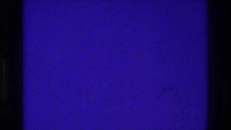 Obscured 1975 Bronx 8mm frame dominated by blue-purple exposure, grain, and dark vertical film-gate bars.