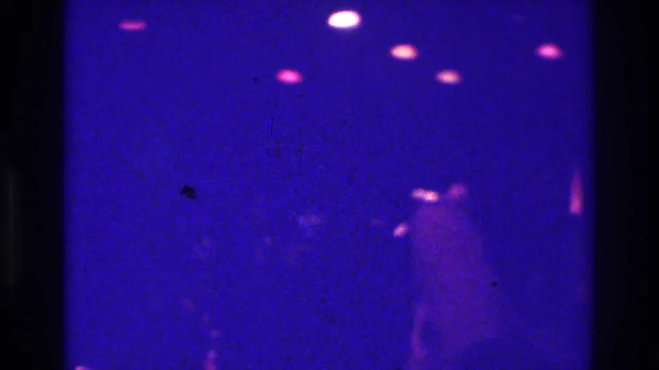 Final frame of the Bronx club scene, with faint dancing figures under purple light and scattered magenta ceiling lights.