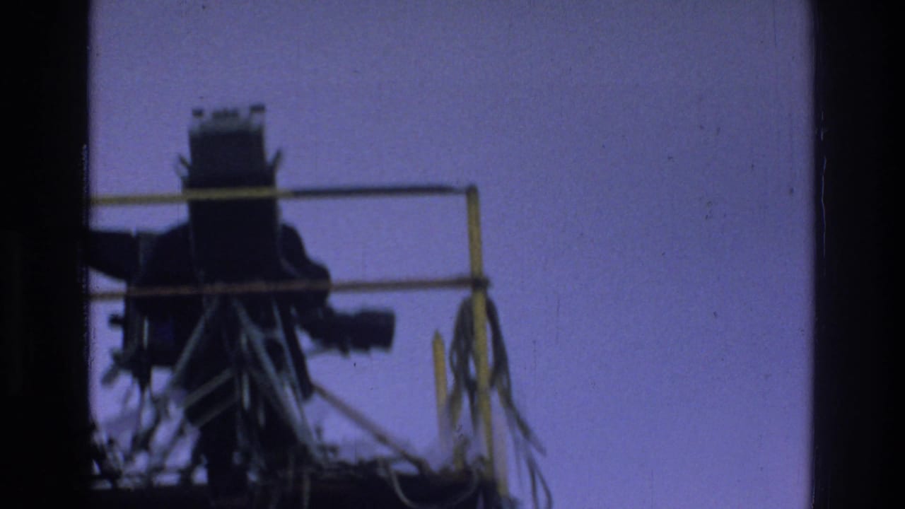 Large camera on a platform silhouetted against a purple sky.