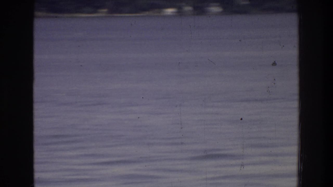 Open river water filling the frame with strong blue-purple color fading; minimal other content visible, faint possible object at far distance.