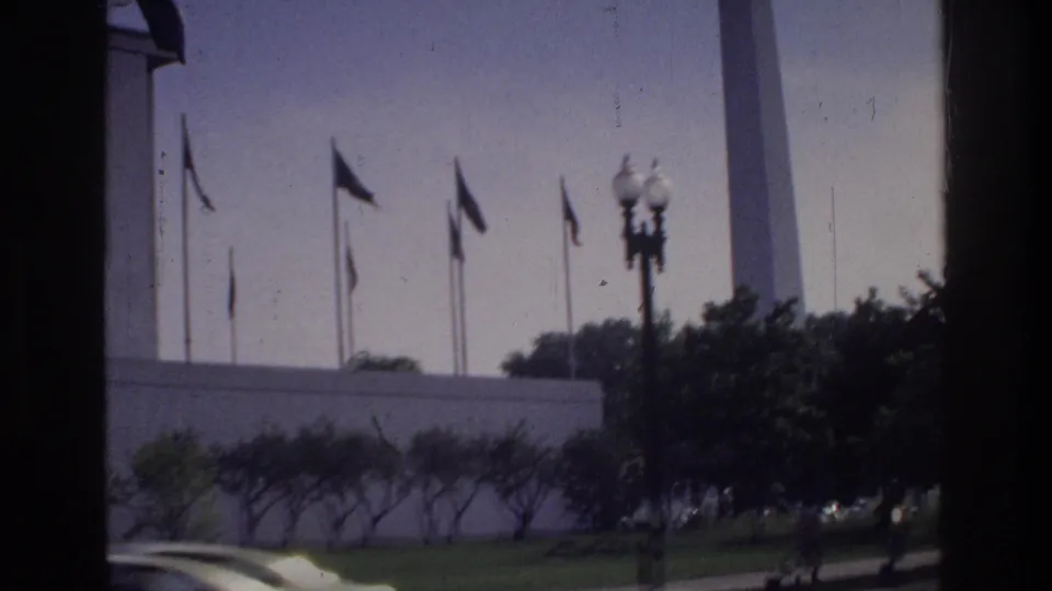 Washington Monument behind a row of flag poles with globe lamp in foreground, Washington DC circa 1975, 8mm home movie