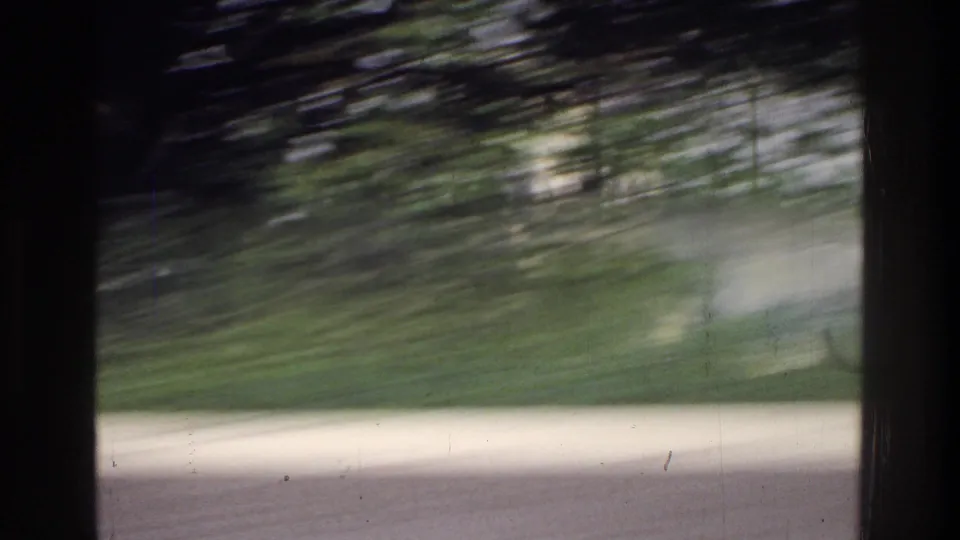 Opening frame of a 1975 8mm home movie, heavily motion-blurred, showing trees and what may be the edge of the Jefferson Memorial grounds, Washington DC.