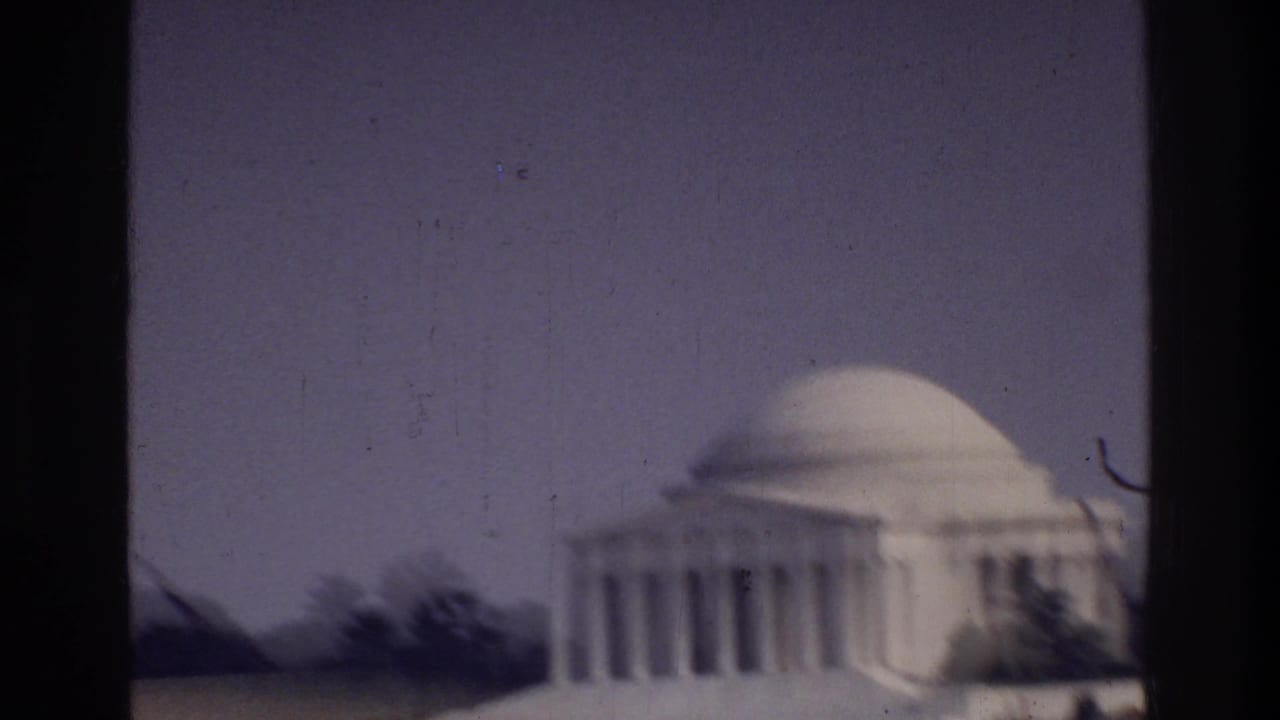 Jefferson Memorial neoclassical dome and colonnade, Washington DC, c. 1975, captured on 8mm film with visible grain and dark film borders.