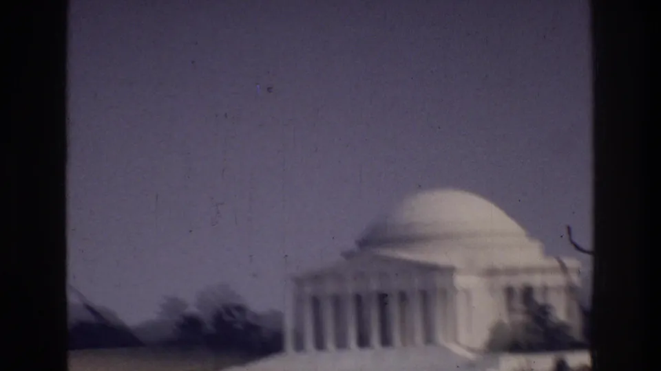 Jefferson Memorial neoclassical dome and colonnade, Washington DC, c. 1975, captured on 8mm film with visible grain and dark film borders.