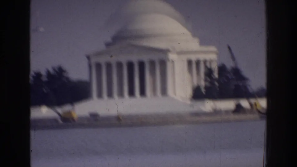 Jefferson Memorial partially motion-blurred, Washington DC, c. 1975, with Tidal Basin water in foreground and yellow objects at the waterline suggesting maintenance or landscaping activity.