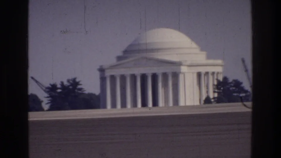 Jefferson Memorial, Washington DC, c. 1975, on 8mm film; Tidal Basin foreground, flanking trees, and a vertical element at right that may indicate construction or maintenance activity.