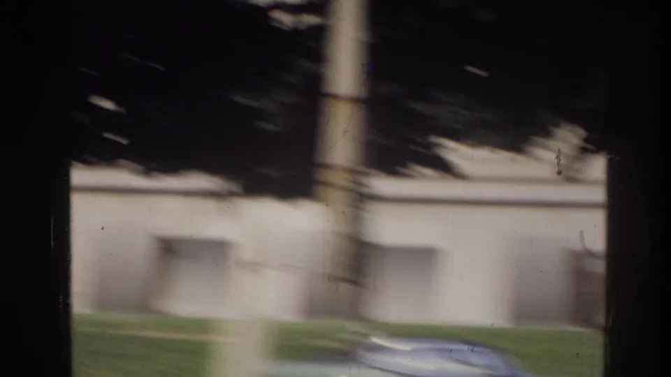 Blurred drive-by of a light-colored rectangular federal-style building with window rows, Washington DC area, circa 1975.