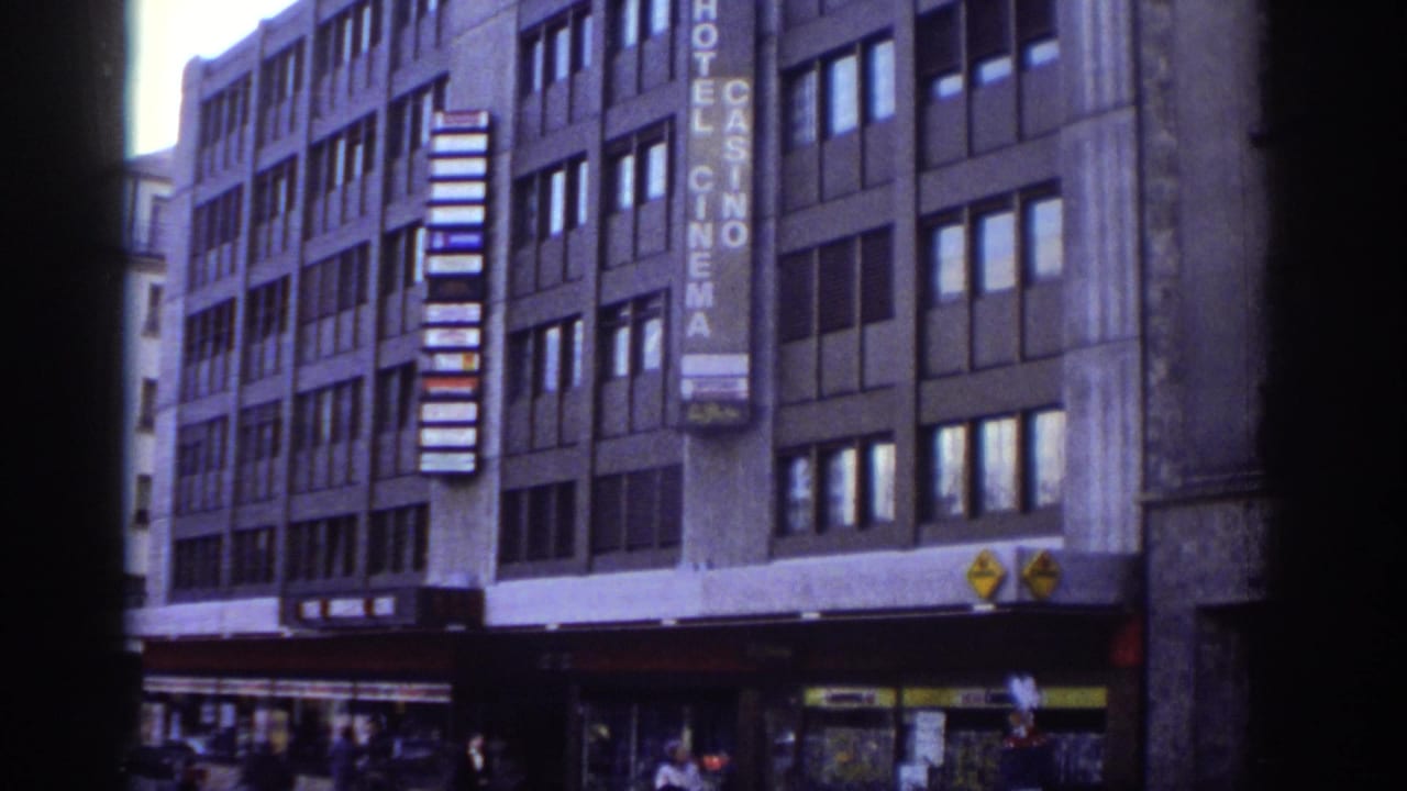 Right-shifted view of same Bern building; vertical Hotel Casino Cinema sign clearly readable; street-level activity visible.