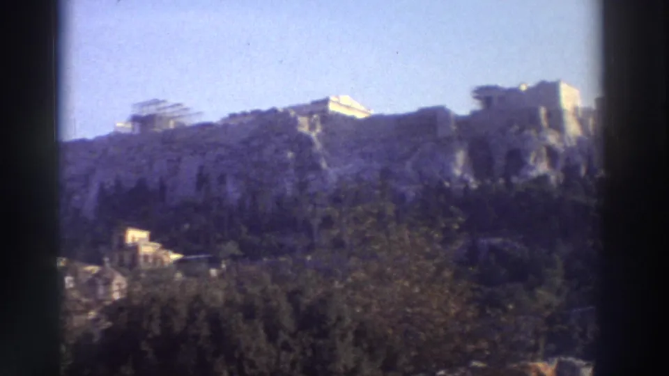 Wider 8mm view of the Acropolis revealing lower Athens buildings at the hill base, circa 1976.