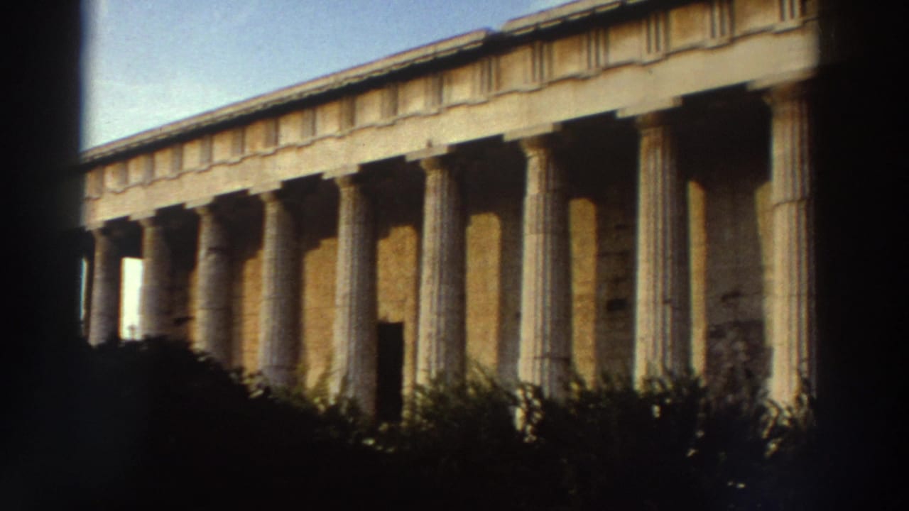 Side colonnade of the Temple of Hephaestus, Athens, c. 1976, in warm afternoon light with low vegetation at the column bases.