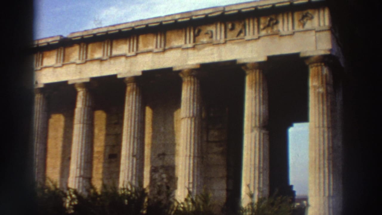 Close view of a well-preserved Doric temple facade in Greece, circa 1976, with warm film grain and characteristic 8mm frame vignetting.