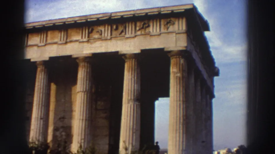Panned view of Greek Doric temple showing full column row and frieze detail, circa 1976 Greece, 8mm film with visible vignetting.