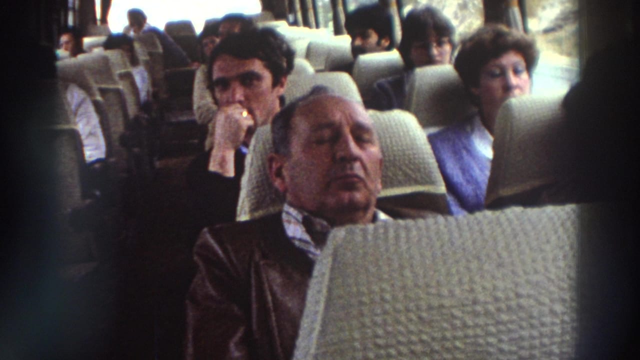 Older man resting with eyes closed in a bus seat; woman in glasses and young man seated behind him.