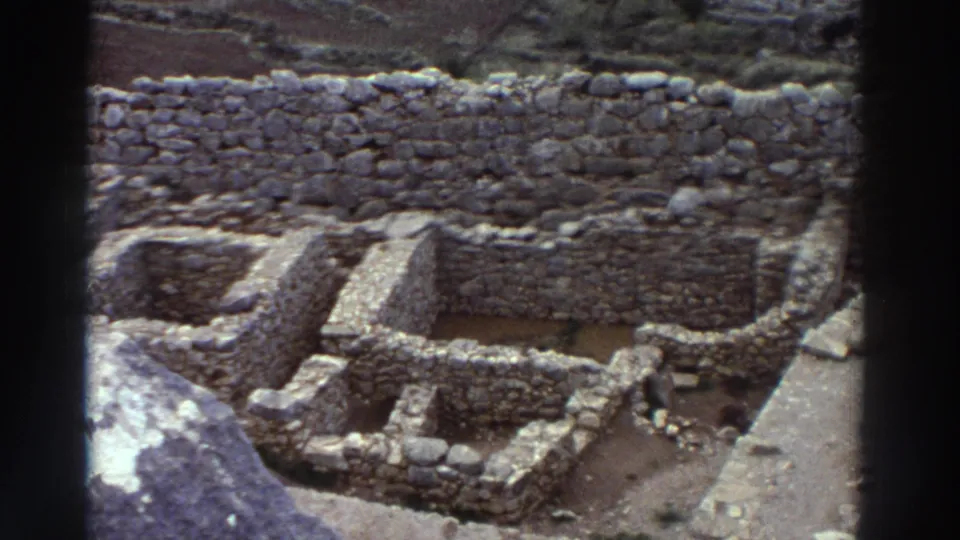 8mm footage from Greece, 1976: overhead view of rectangular dry-stone room foundations at an ancient archaeological site, dry earth exposed within the walls.