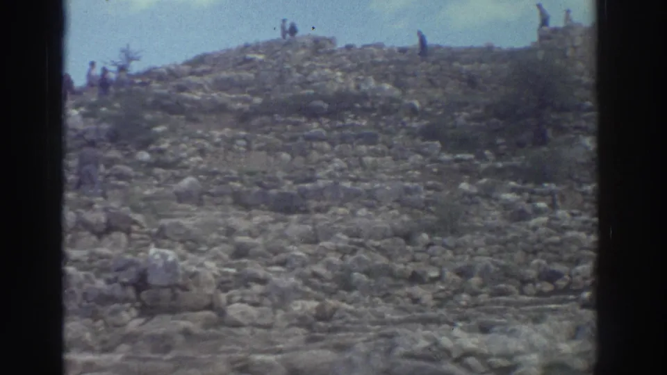 Faded 8mm footage of a rocky hillside strewn with ancient stone ruins and numerous visitors, Greece, 1976